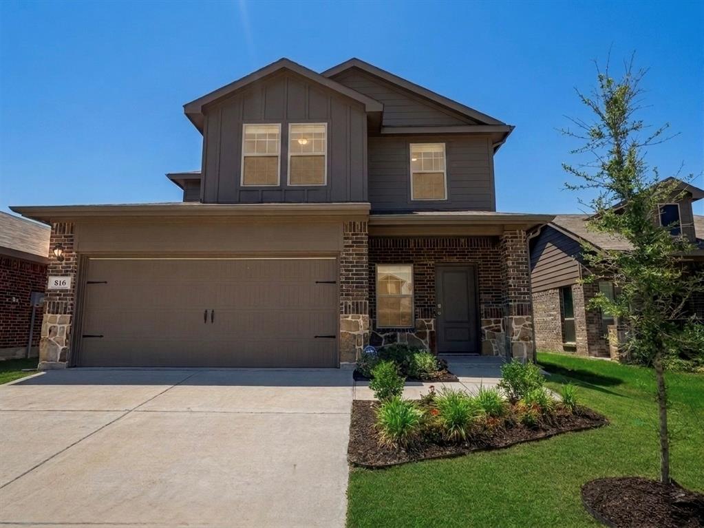 Contemporary two-story residence featuring a combination of dark brick and stone veneer accents
