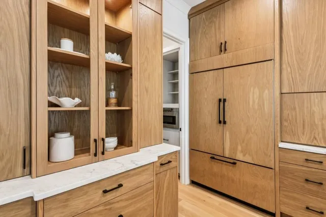 a large kitchen with stainless steel appliances a lot of counter space and a wooden floors