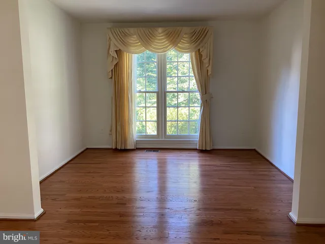 a view of a room with wooden floor and a window