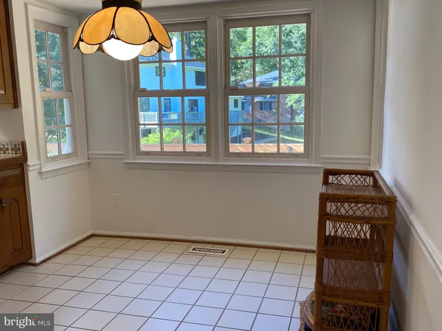 an empty room with a window and a chandelier