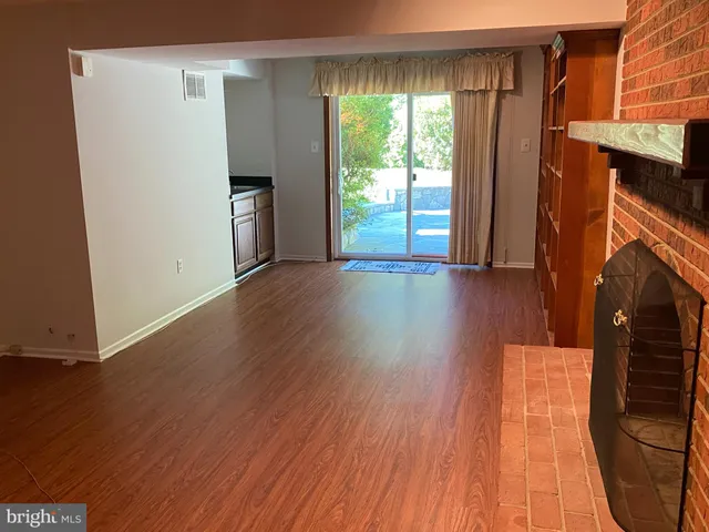 an empty room with wooden floor and a window