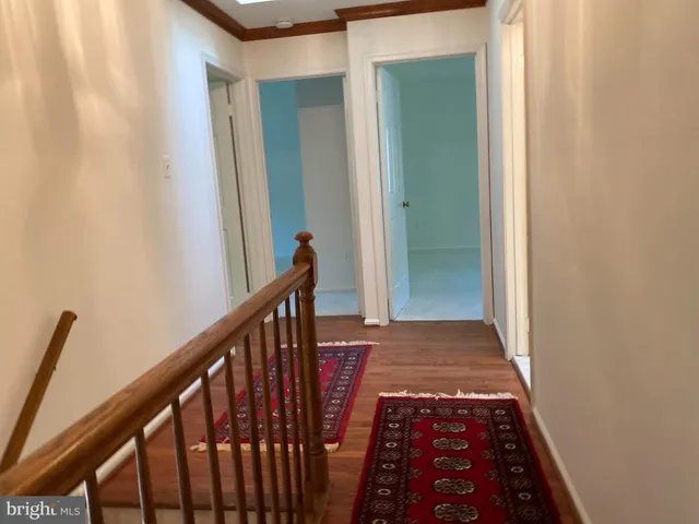 a view of a hallway with wooden floor and stairs