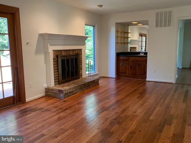 a view of a livingroom with wooden floor and a fireplace