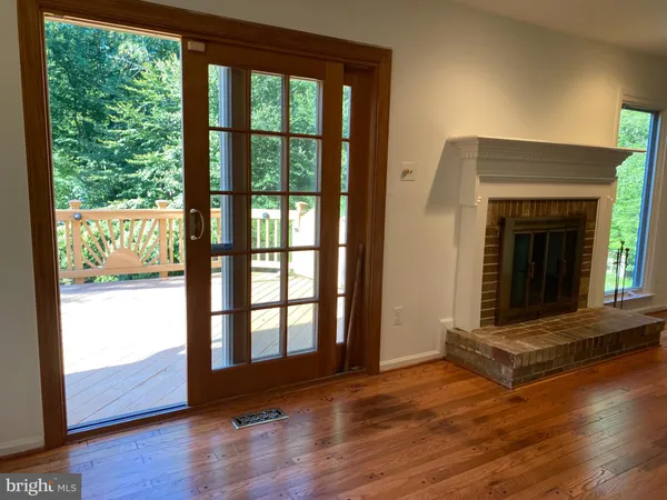 wooden floor fireplace and windows in an empty room
