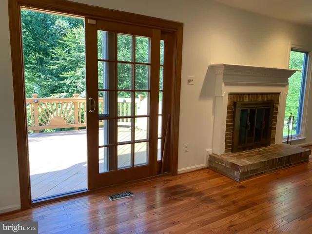 wooden floor fireplace and windows in an empty room