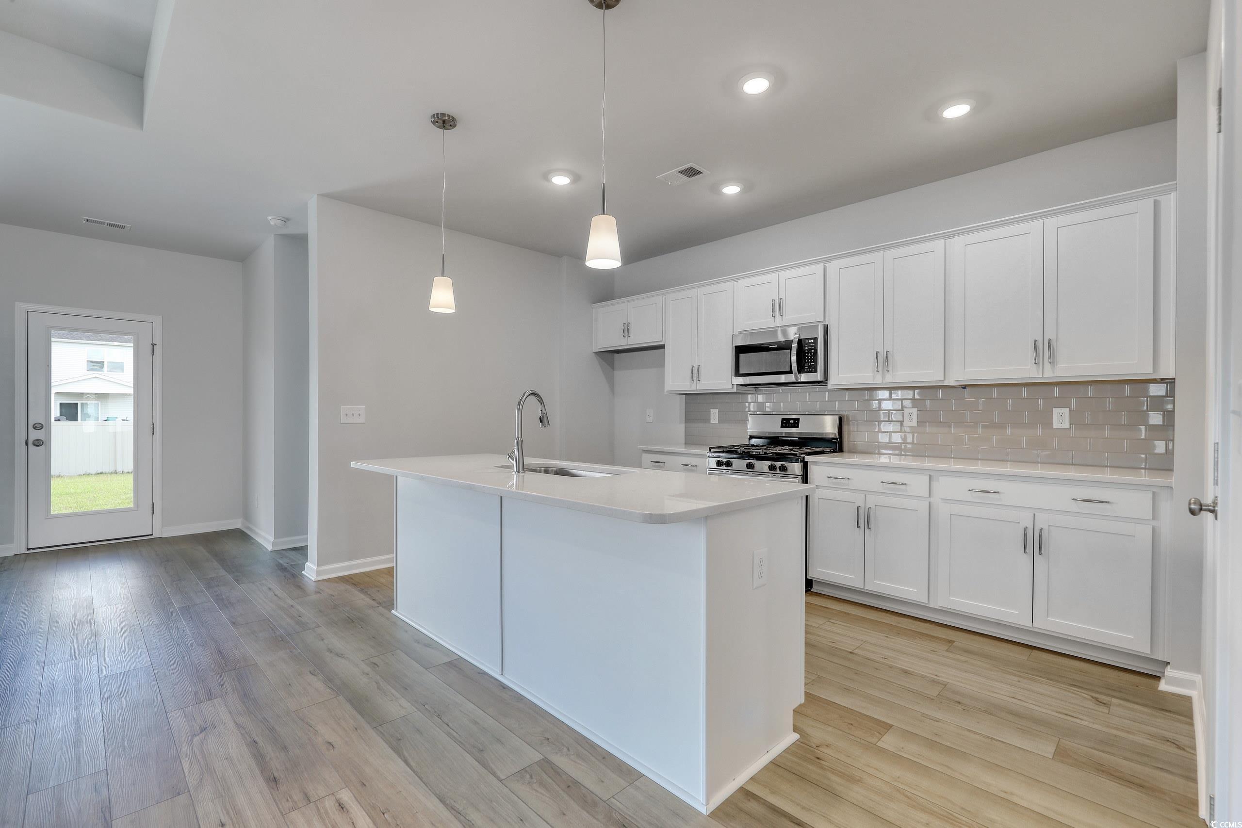 Kitchen featuring sink, hanging light fixtures, wh