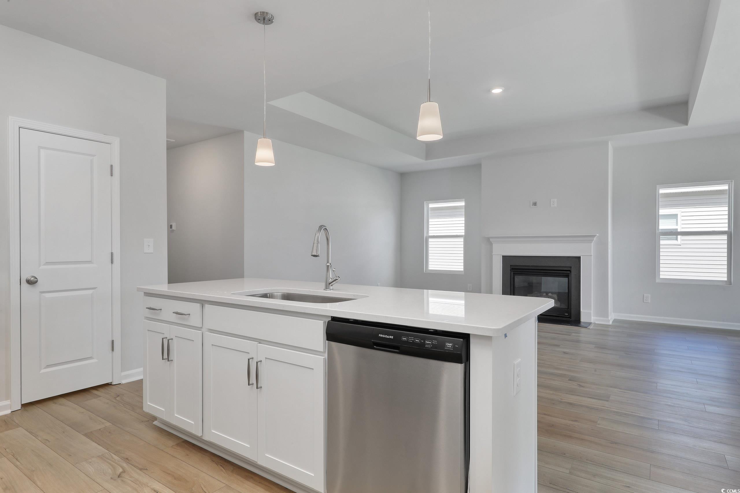 Kitchen with white cabinets, an island with sink,