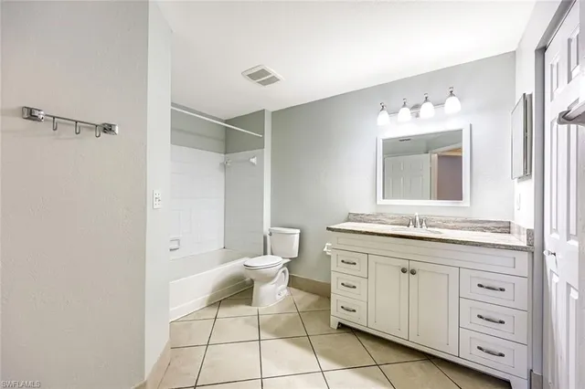 a spacious bathroom with a granite countertop sink mirror and toilet