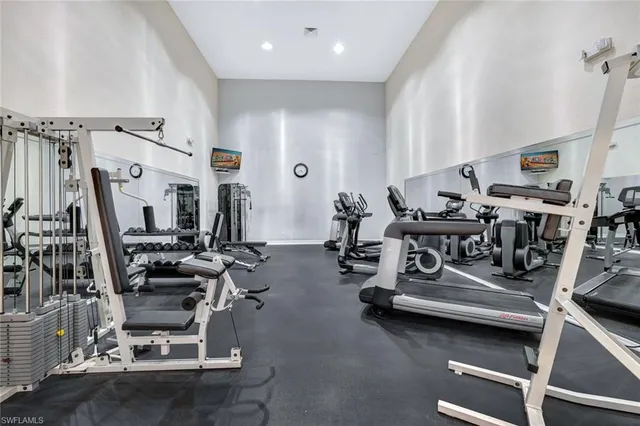 a room with gym equipment and wooden floor
