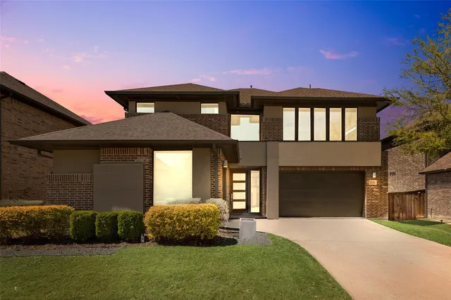 a front view of a house with a garden and parking