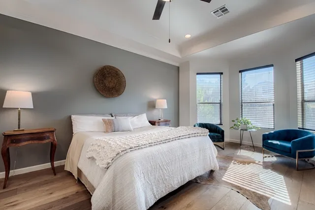 a bedroom with a bed a couch and a large window