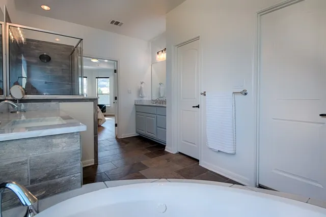 a bathroom with a granite countertop sink mirror and shower