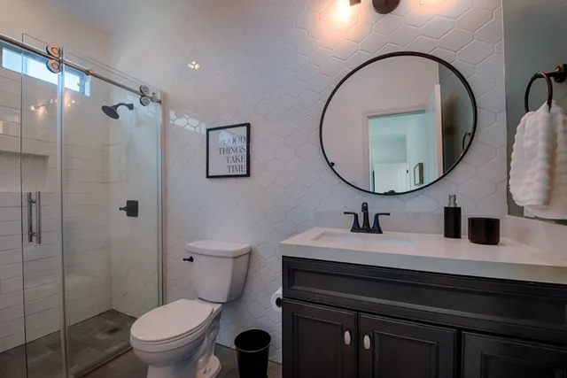 a bathroom with a sink a toilet and a mirror