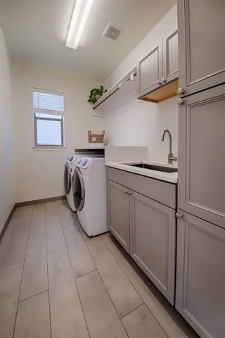 a utility room with cabinets washer and dryer