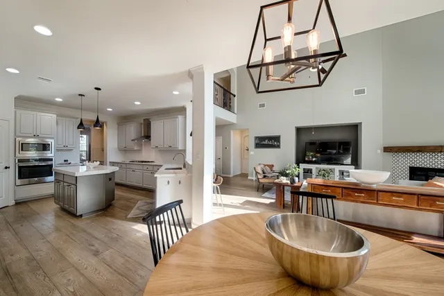 a dining room with stainless steel appliances granite countertop a couch and a view of living room