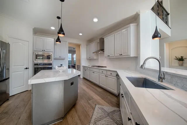 a kitchen with stainless steel appliances granite countertop a sink stove and refrigerator