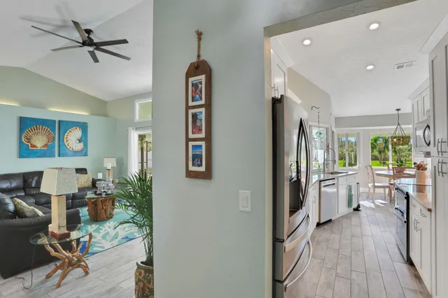 a dining room with wooden floor a chandelier a glass table and chairs