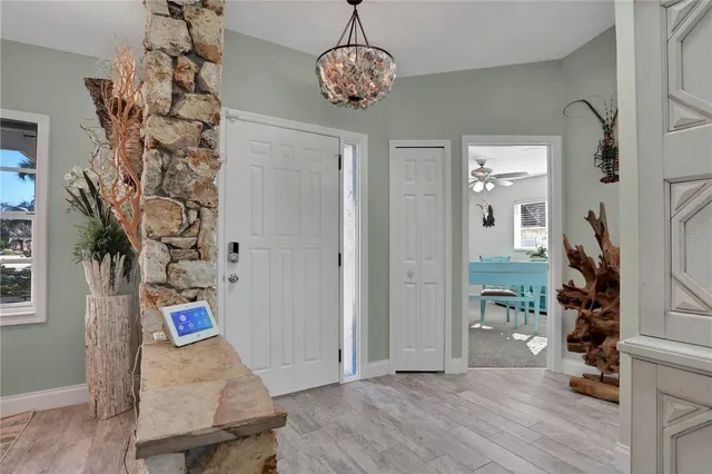 a dining room with furniture a rug and a floor to ceiling window