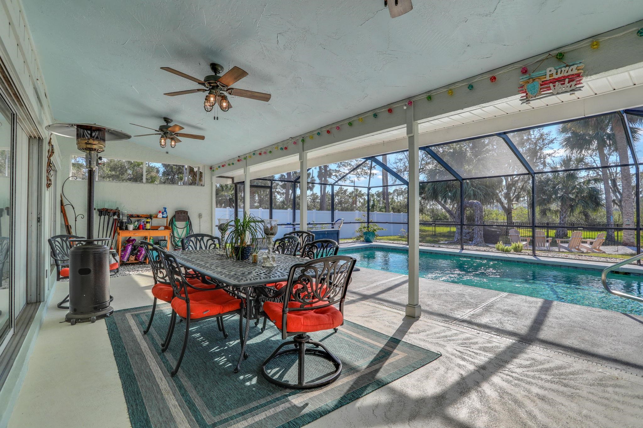 1075 Lambert Avenue Flagler Beach, FL 32136 - Photo 45 of 71 a view of a dining room with furniture wooden floor and a chandelier