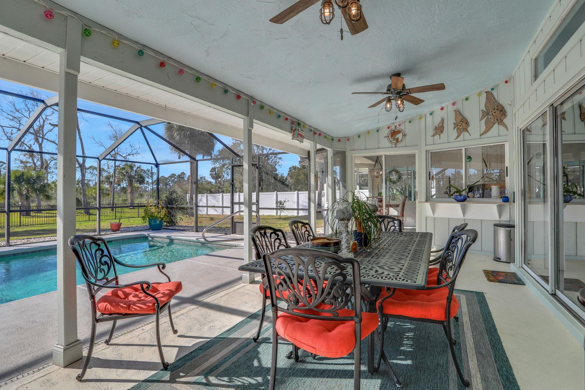 1075 Lambert Avenue Flagler Beach, FL 32136 - Photo 46 of 71 a dining room with furniture a rug and a floor to ceiling window