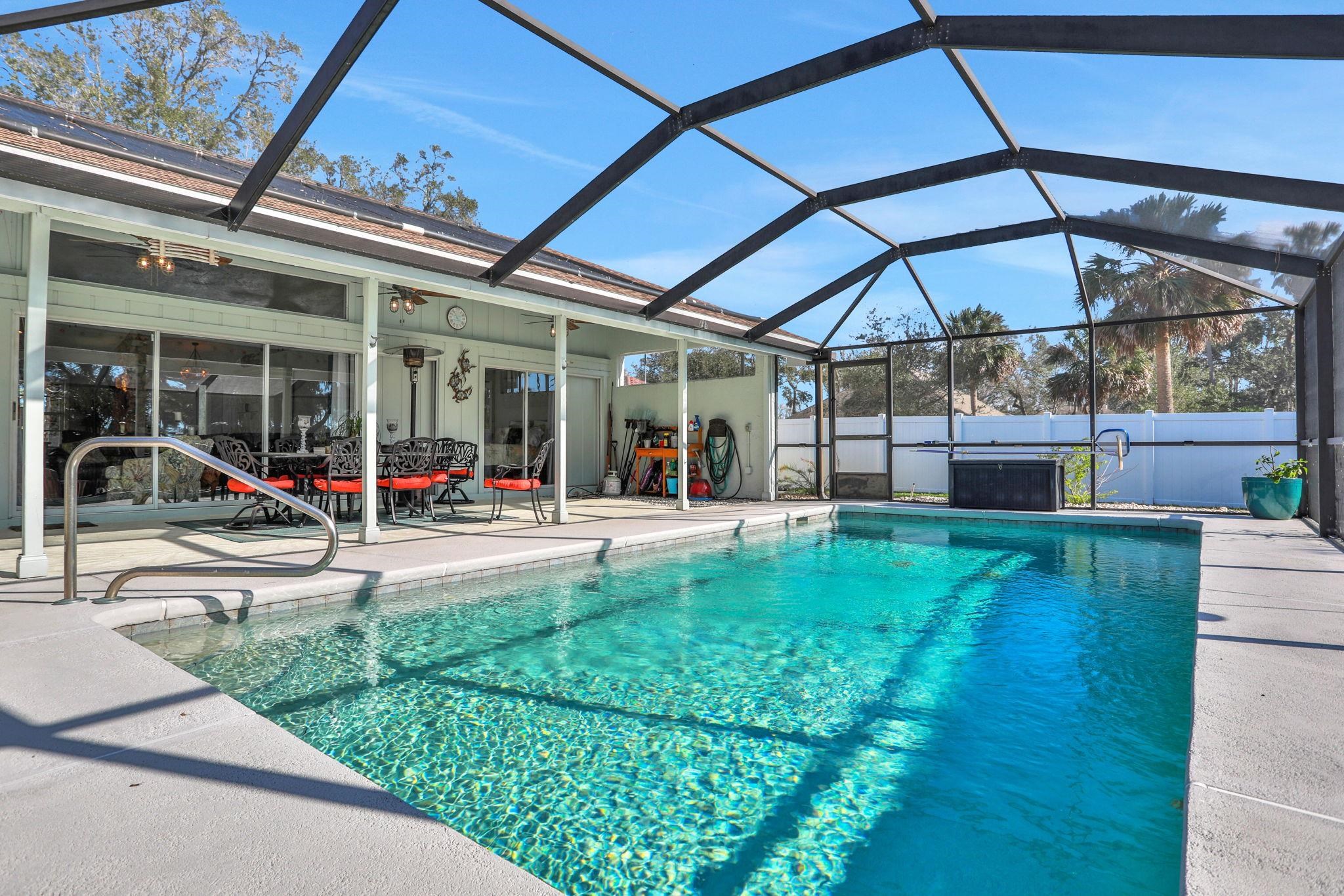 1075 Lambert Avenue Flagler Beach, FL 32136 - Photo 48 of 71 a view of a backyard with a table and chairs under an umbrella