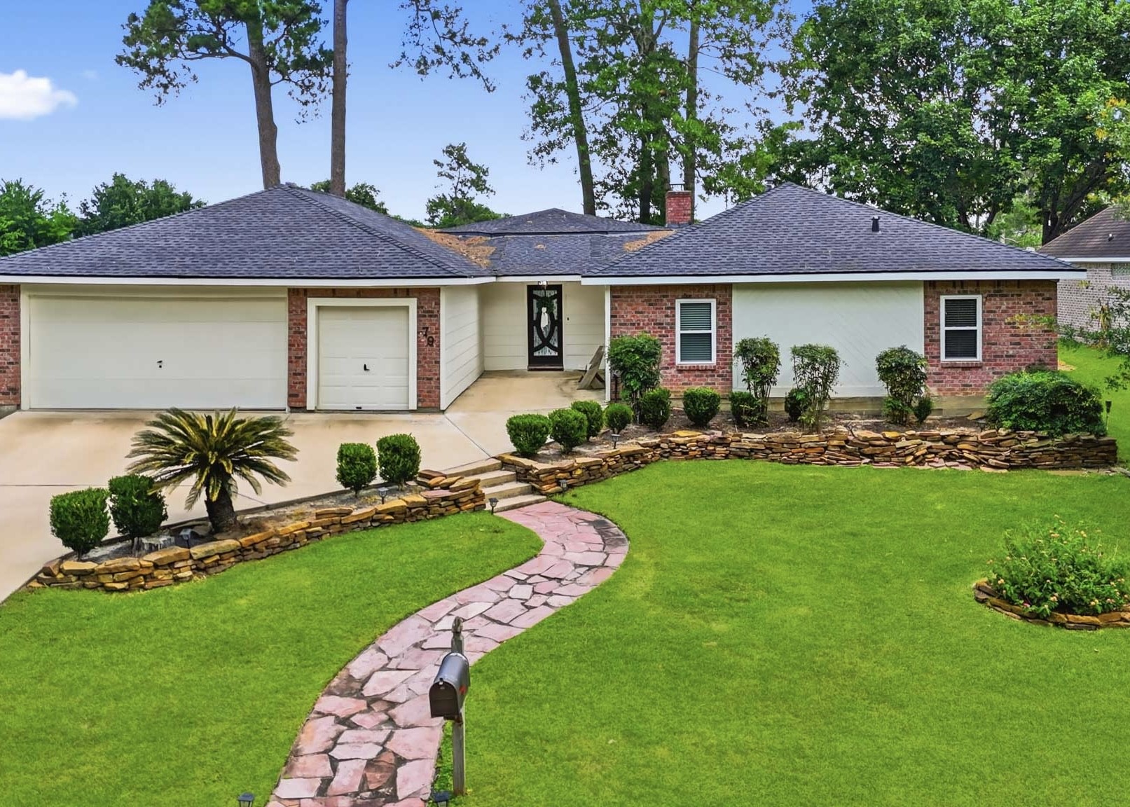 79 Summers Wind Street Conroe, TX 77356 - Photo 1 of 45 a front view of a house with a garden and patio