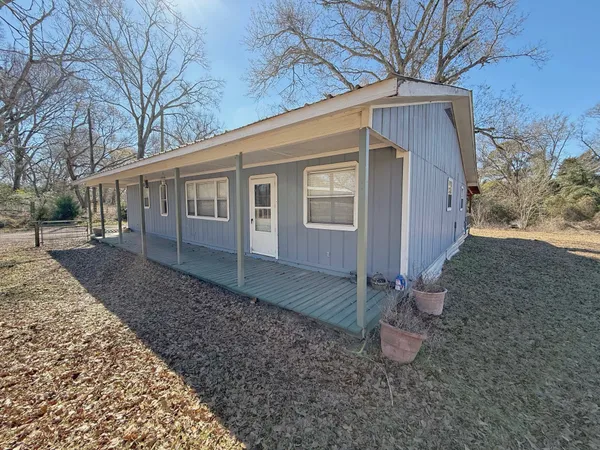 a view of a house with a yard and large tree