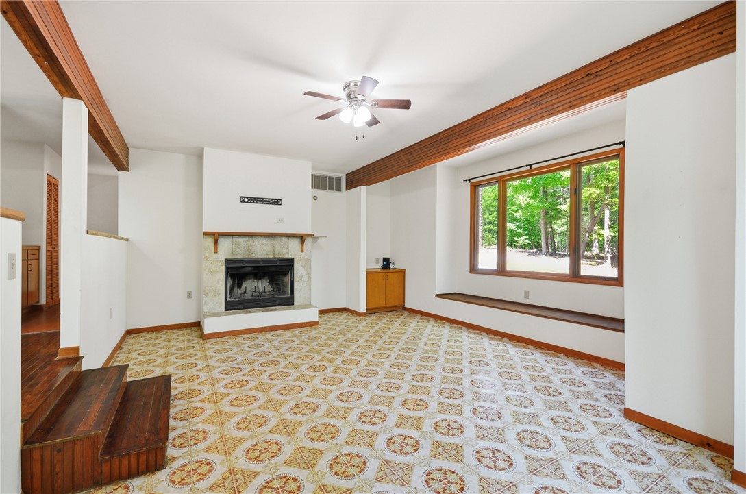 1298 Carradine Road Seneca, SC 29678 - Photo 22 of 43 A cozy living space features a prominent fireplace and a scenic window seat overlooking lush greenery.