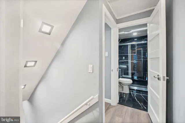 a view of a hallway with wooden floor and dining room