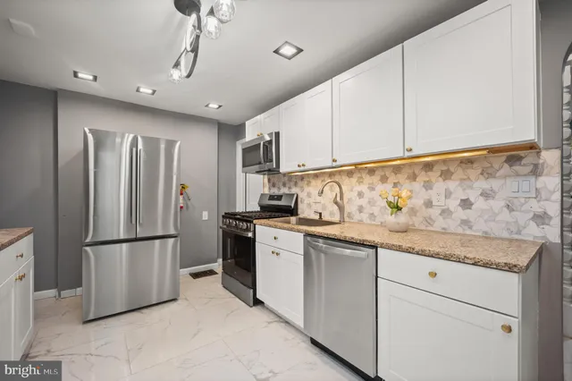 a kitchen with granite countertop stainless steel appliances and refrigerator