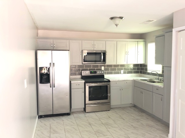 4603 Talley Road Millington, TN 38053 - Photo 4 of 16 a kitchen with a sink stainless steel appliances and cabinets
