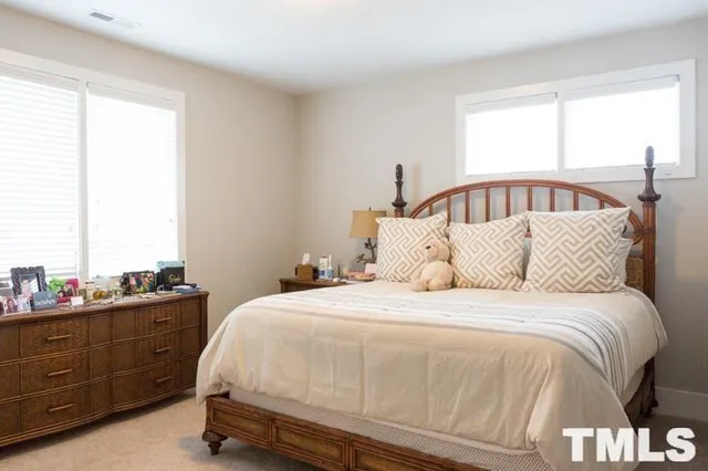 a large bed sitting in a bedroom next to a window