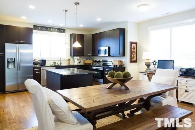 a kitchen with a dining table cabinets appliances and a window