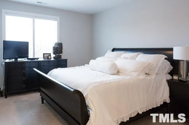 a bed sitting in a bedroom next to a window