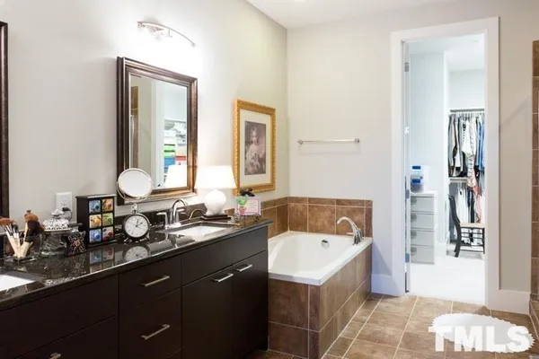 a bathroom with a tub double sink window and mirror