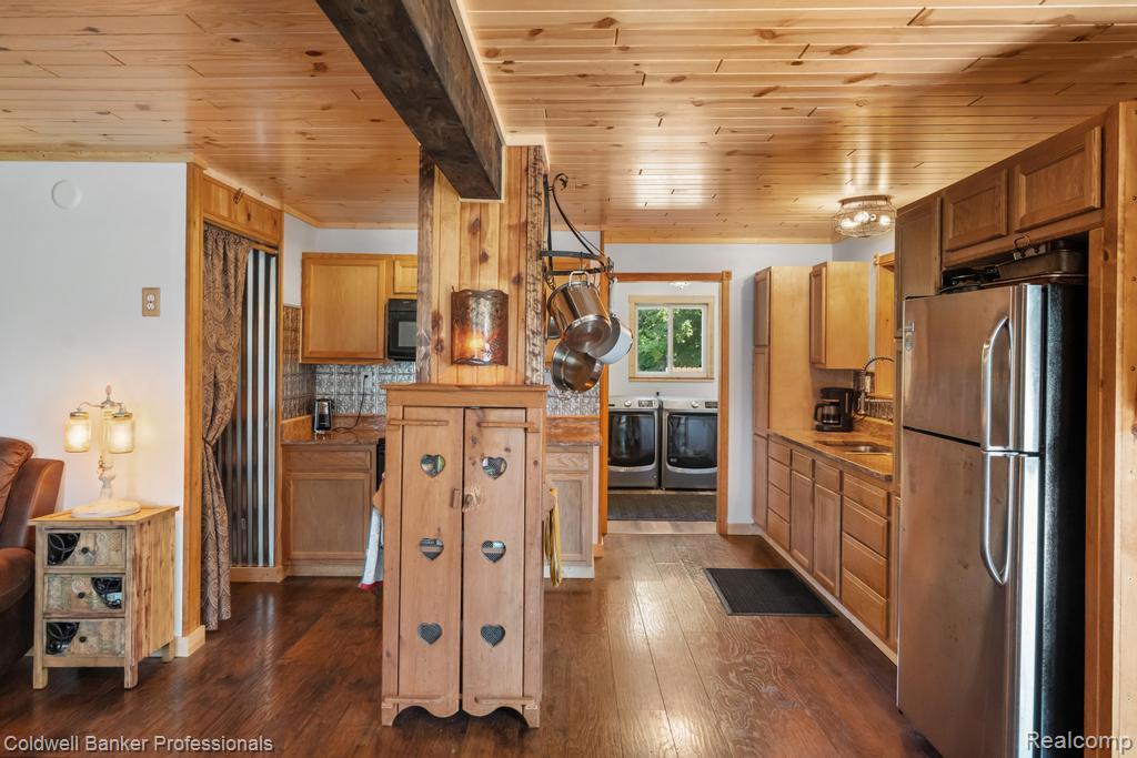 6389 Postlewait Road Mancelona, MI 49659 - Photo 18 of 50 Wood-finish flooring throughout, complemented by wood paneling and a wood plank ceiling