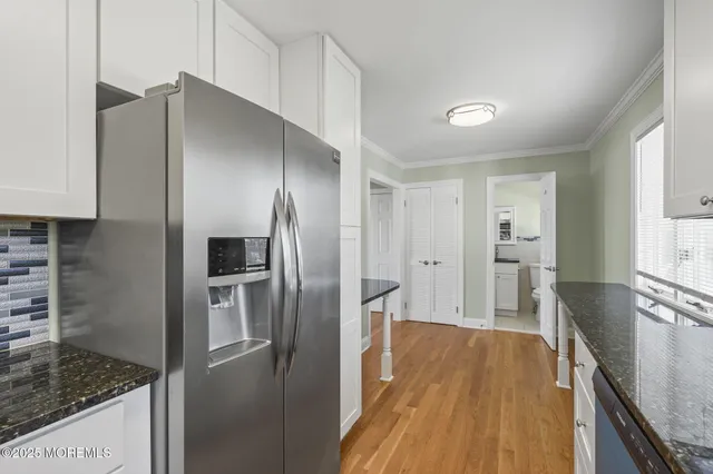 a kitchen with stainless steel appliances granite countertop a refrigerator and a stove