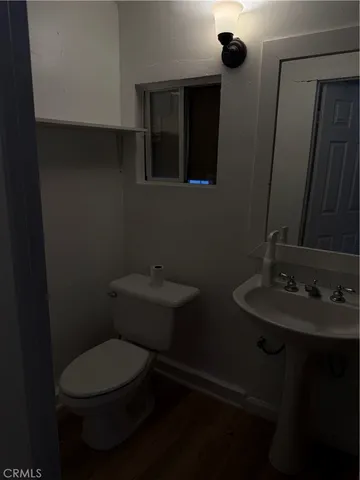 a bathroom with a toilet a sink and mirror