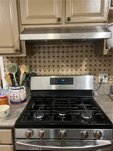 a stove top oven sitting inside of a kitchen