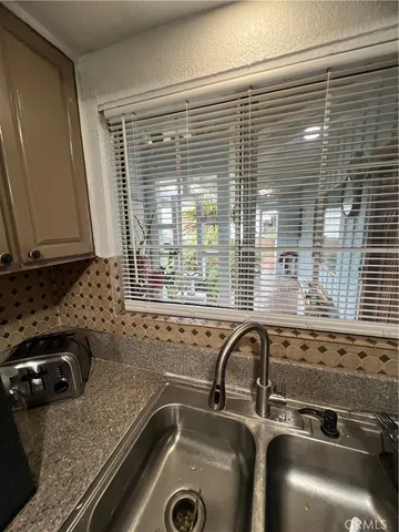 a bathroom with a granite countertop sink and a large mirror