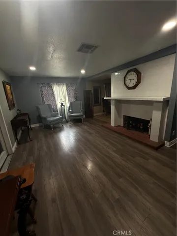 an empty room with wooden floor a fireplace and a window