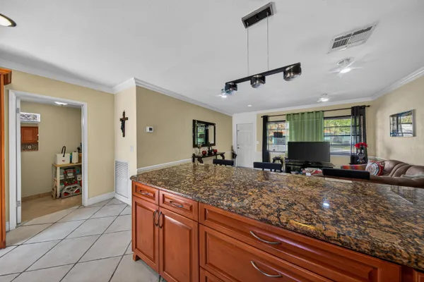 a kitchen with kitchen island granite countertop a sink and refrigerator