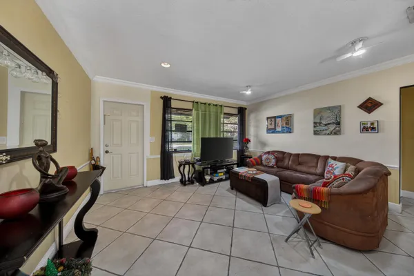 a living room with furniture a flat screen tv and a window
