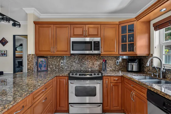 a kitchen with stainless steel appliances granite countertop a stove microwave and sink