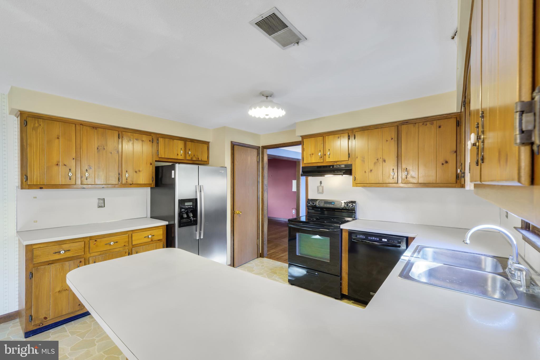 2333 Three Mile Run Road Perkasie, PA 18944 - Photo 10 of 43 a kitchen with stainless steel appliances granite countertop a sink refrigerator and cabinets