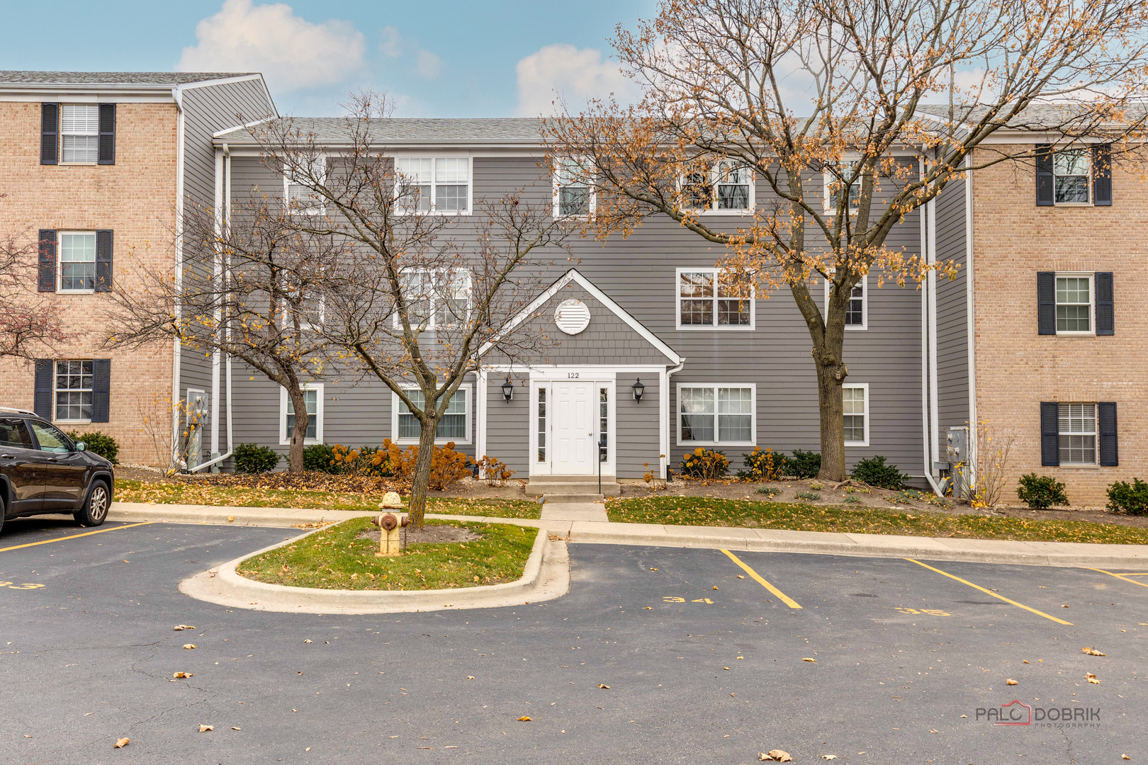 122 East Winchester Road, Unit E Libertyville, IL 60048 - Photo 1 of 17 a front view of a residential houses with yard