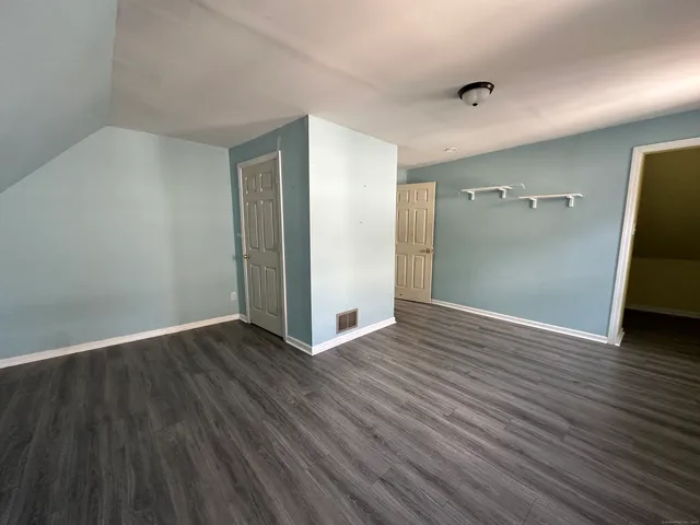 an empty room with wooden floor and closet
