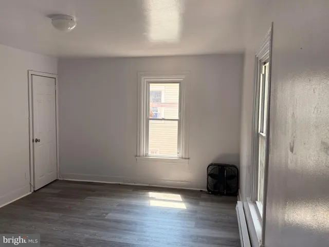 an empty room with wooden floor and a window