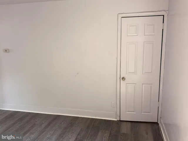 an empty room with wooden floor and closet