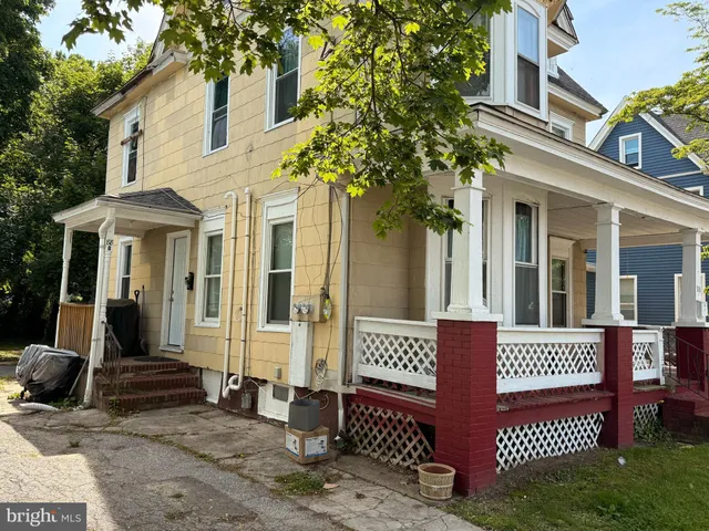 a view of a brick house with large windows and a tree